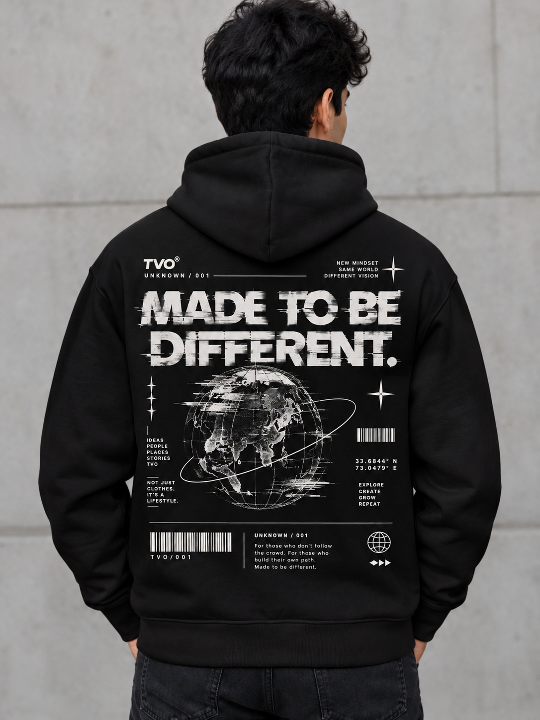 A man viewed from behind wearing a black hoodie with a large white graphic print on the back. The design features the text 'MADE TO BE DIFFERENT.