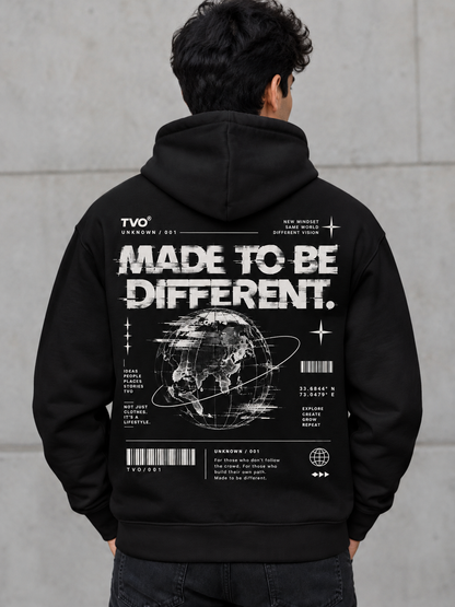 A man viewed from behind wearing a black hoodie with a large white graphic print on the back. The design features the text 'MADE TO BE DIFFERENT.