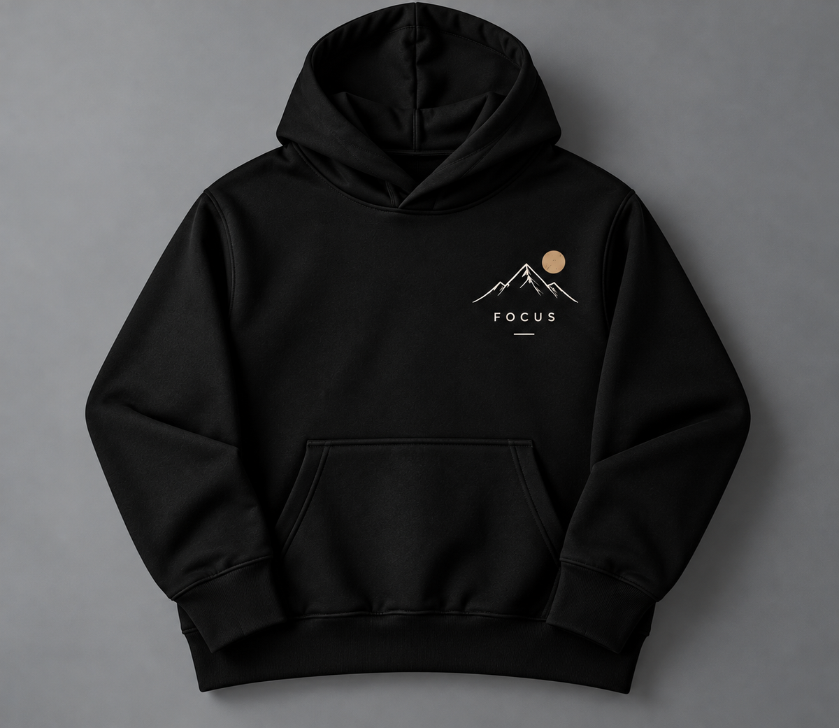 A black pullover hoodie with a small chest graphic showing a white mountain and sun design above the word 'FOCUS', displayed on a neutral gray background.