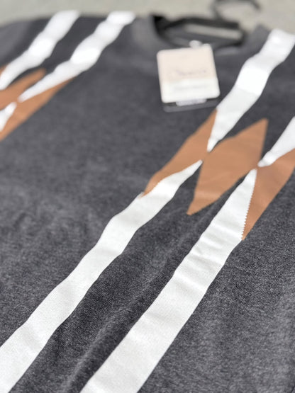 Close-up of a dark gray knit sweater with bold white vertical stripes and tan geometric accents, featuring a hangtag near the neckline.