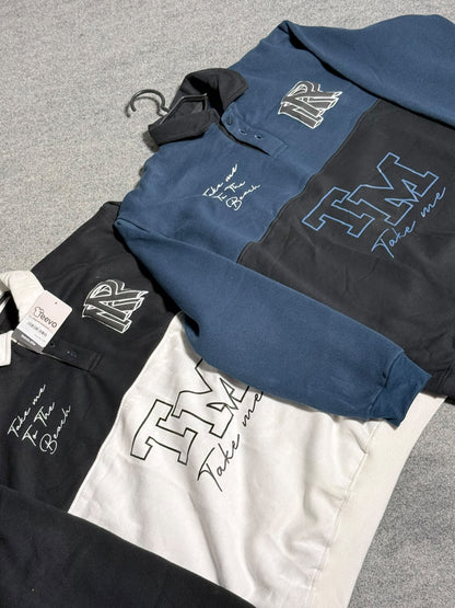 A long-sleeve collared shirt laid flat on a gray textured surface, shown in three colorways: blue, black, and white. Each colorway features a large outlined 'TM' logo on the front, script text reading 'Talk like a Boss' on the sleeve, and a matching embroidered 'TM' patch on the chest.