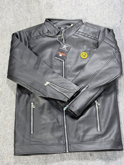 A black faux leather jacket with a stand collar, front zipper, zippered pockets, and a small yellow circular patch on the chest, laid flat on a gray textured surface.