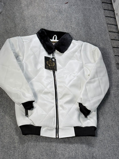 A white quilted bomber jacket with black ribbed trim, a black collar, and a black zipper, laid flat on a gray carpet. A hangtag is attached to the zipper.